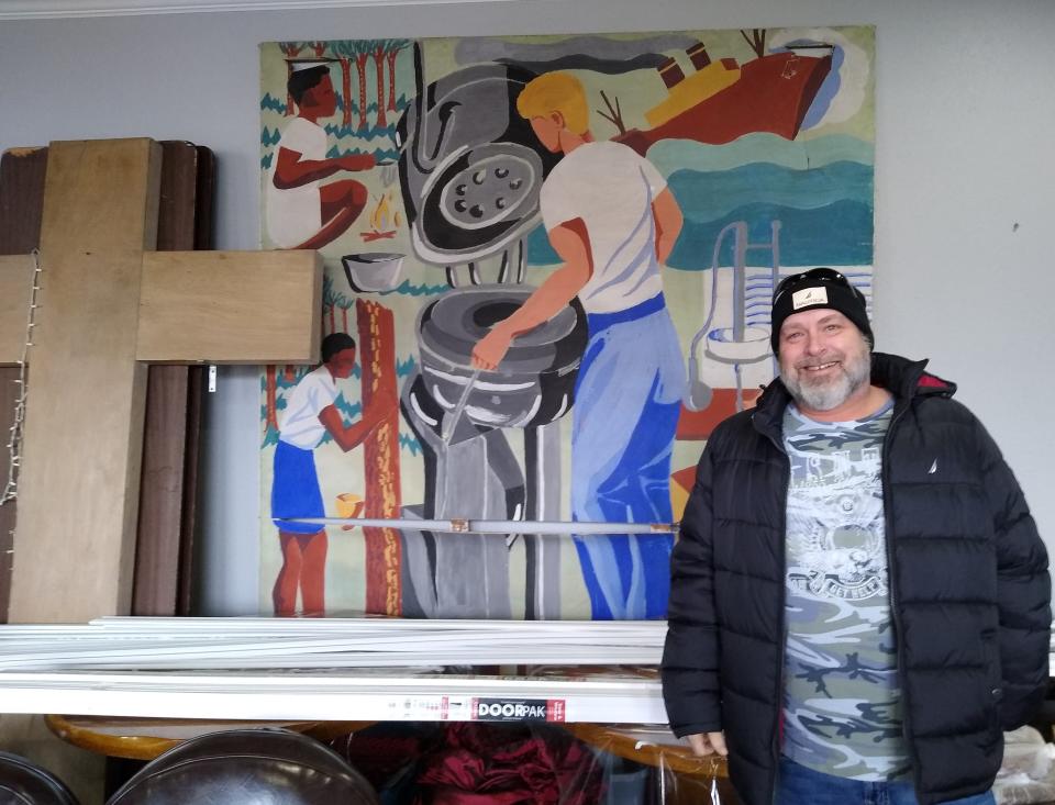 Tugg Massa, founder of the New Beginnings thrift store on Kenmore Boulevard in Akron, stands Saturday next to a 1947 student mural that used to hang in Lawndale Elementary School.