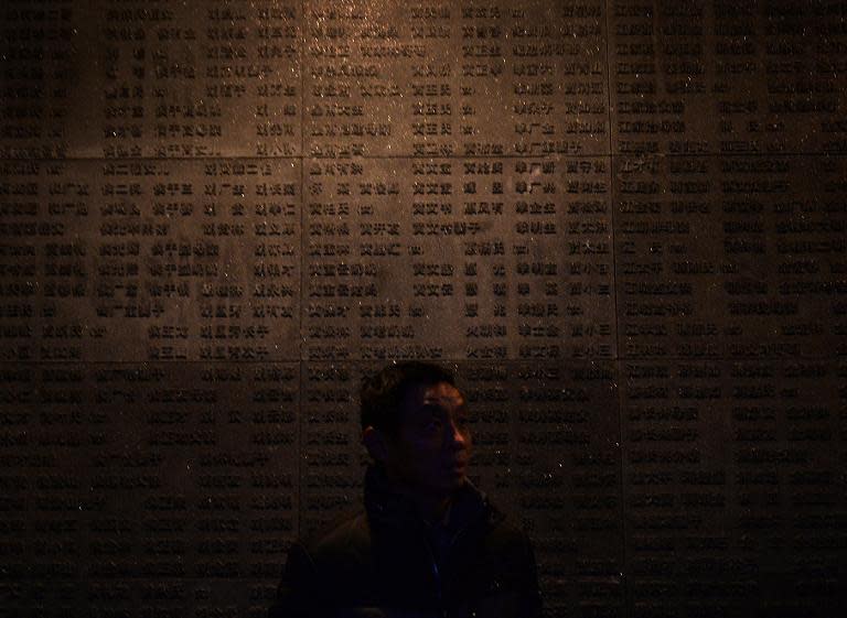 A Chinese tourist views the names of victims of Japanese war crimes, at the Nanjing Massacre Memorial Museum, in Nanjing, on February 12, 2014