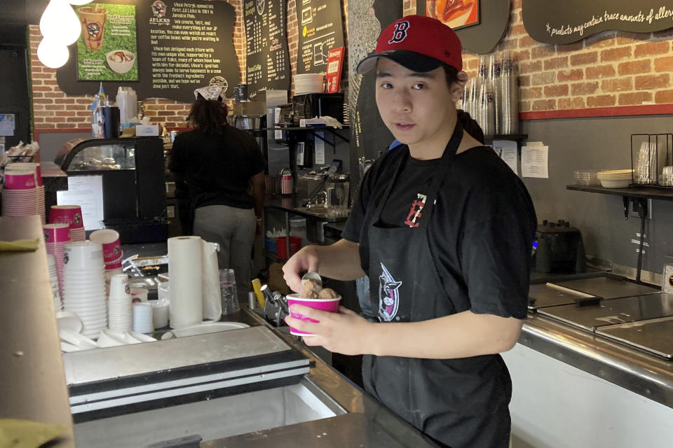 Christopher Au, 19, dishes out ice cream at a J.P. Licks in Boston’s Beacon Hill neighborhood on Thrusday, May 25, 2023. Au, who has worked at the shop for the past few months, said that having a job helps him be more independent and not to have to rely on his parents too much for spending money. Teens willing to work hold even more sway these days, thanks to one of the tightest job markets in decades. (AP Photo/Steve LeBlanc)