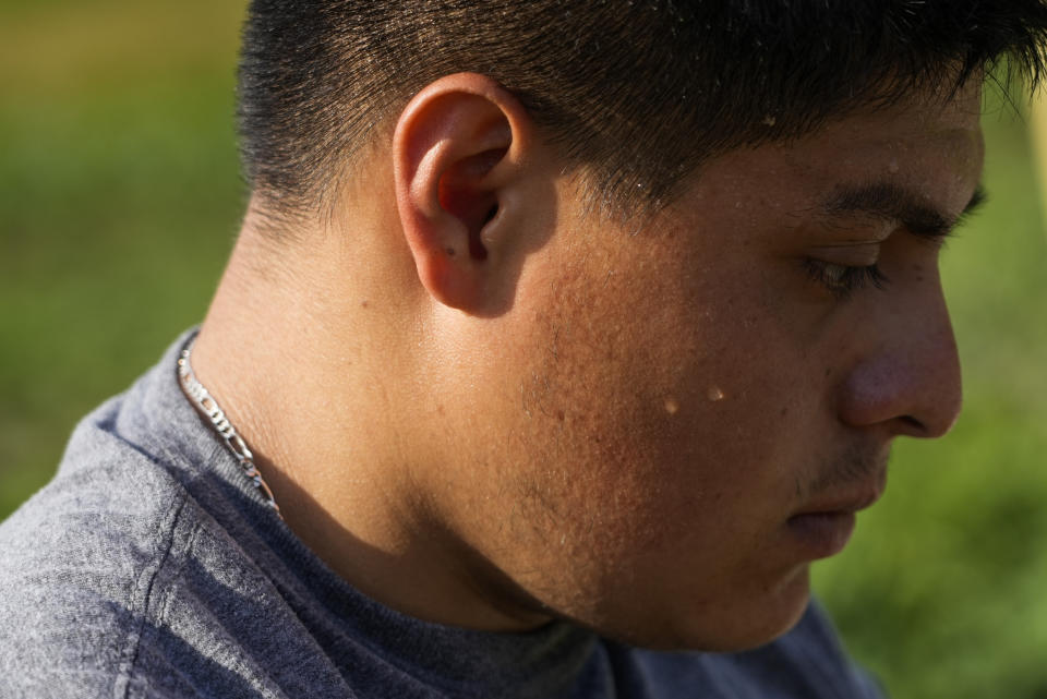 Sweat drips down the cheek of Brayan Manzano as he works, Friday, July 7, 2023, at a farm in Waverly, Ohio. As Earth this week set and then repeatedly broke unofficial records for average global heat, it served as a reminder of a danger that climate change is making steadily worse for farmworkers and others who labor outside. (AP Photo/Joshua A. Bickel)