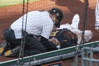 Pittsburgh Pirates trainers check on Phillip Evans (64) and Gregory Polanco, not seen, after they collided along the right field fence while chasing a fly ball by Detroit Tigers' Miguel Cabrera during the sixth inning of a baseball game, Saturday, Aug. 8, 2020, in Pittsburgh. (AP Photo/Keith Srakocic)