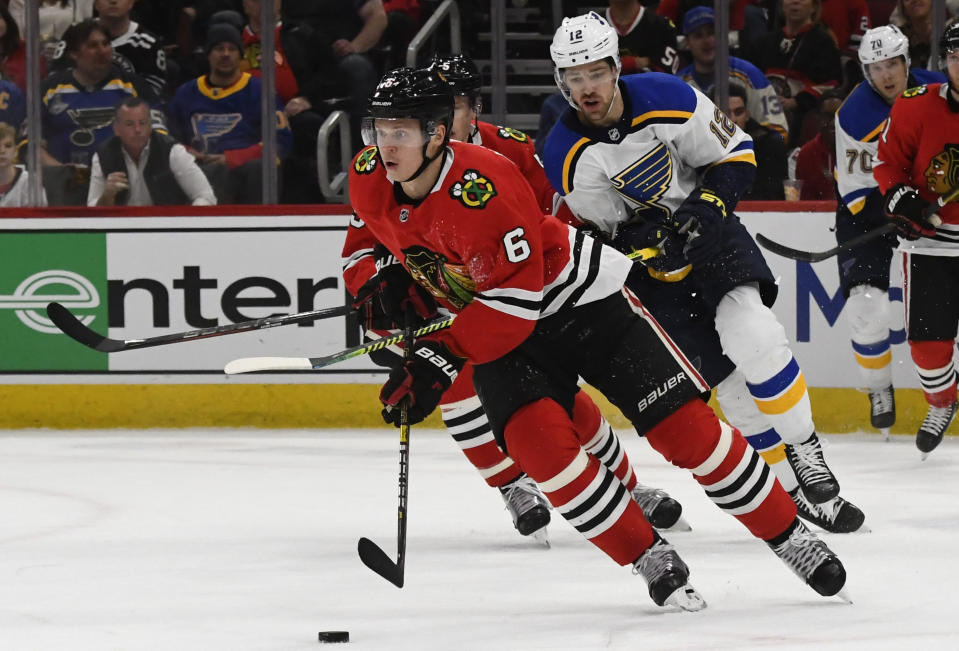 Chicago Blackhawks defenseman Olli Maatta (6) moves the puck away from St. Louis Blues left wing Zach Sanford (12) during the first period of an NHL hockey game between the Chicago Blackhawks and the St. Louis Blues on Sunday March 8, 2020, in Chicago. (AP Photo/Matt Marton)