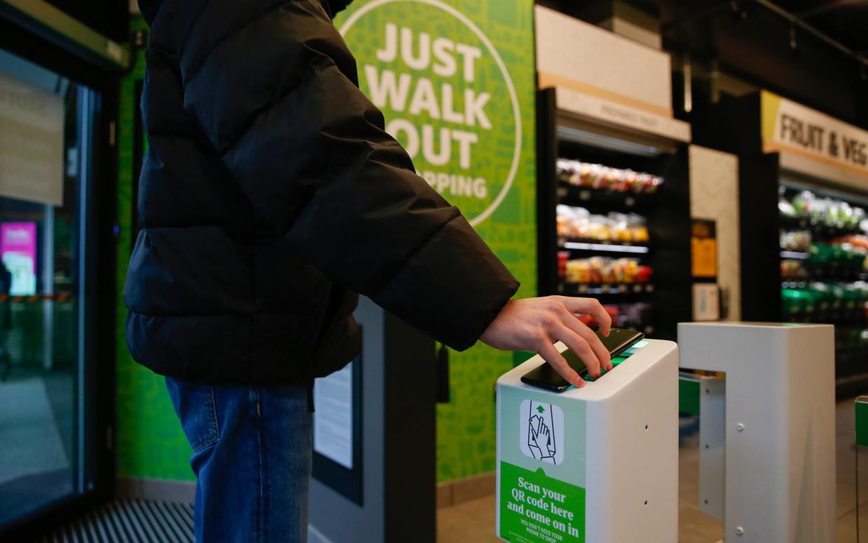 amazon fresh shopper using mobile to enter store - Hollie Adams/Bloomberg