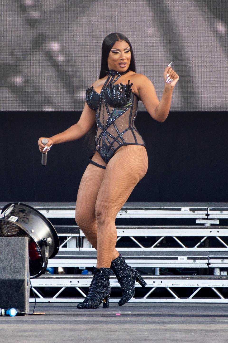 Megan Thee Stallion performs in a black corseted leotard and boots