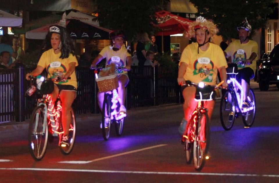 A group draws attention with neon lights on their bicycles.