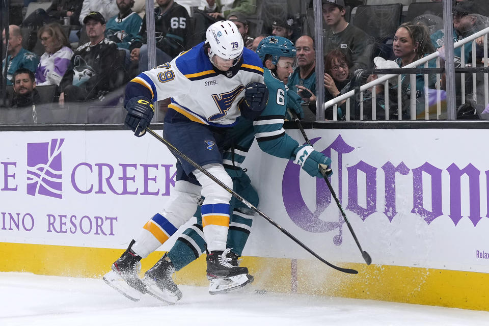 San Jose Sharks defenseman Ty Emberson (6) is checked into the boards by St. Louis Blues left wing Sammy Blais (79) during the second period of an NHL hockey game Thursday, Nov. 16, 2023, in San Jose, Calif. (AP Photo/Tony Avelar)