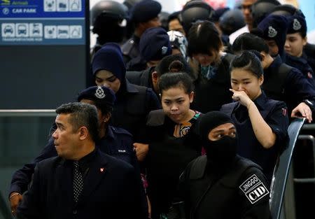 Indonesian Siti Aisyah and Vietnamese Doan Thi Huong, who are on trial for the killing of Kim Jong Nam, the estranged half-brother of North Korea's leader, are escorted as they revisit the Kuala Lumpur International Airport 2 in Sepang, Malaysia October 24, 2017. REUTERS/Lai Seng Sin