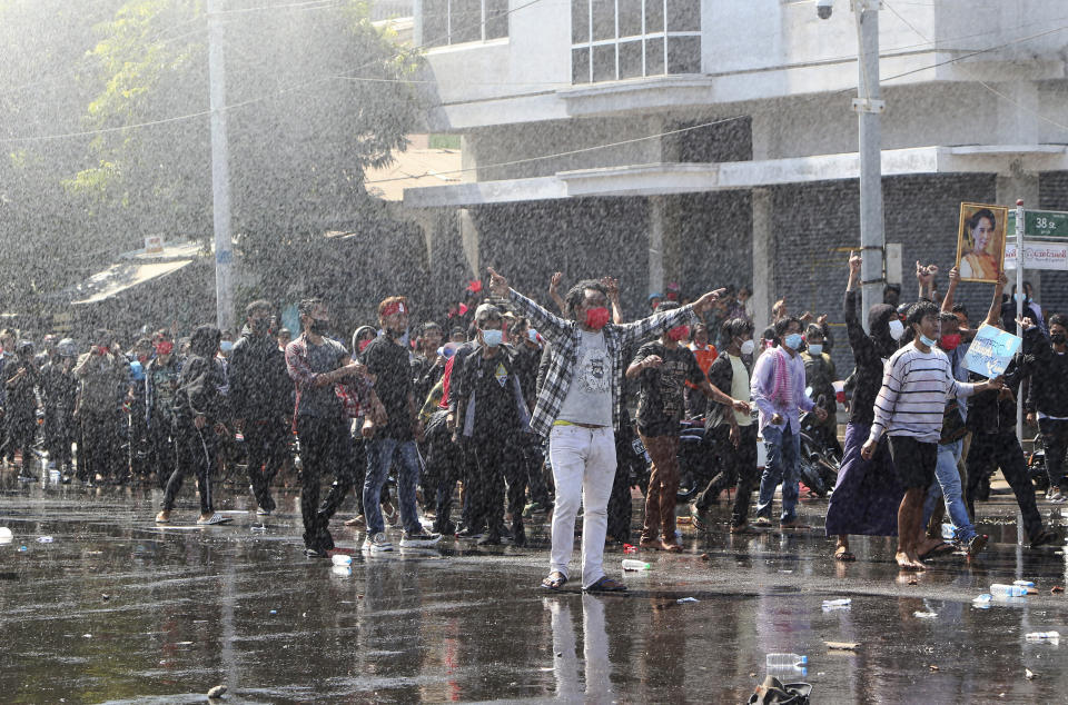Protesters regroup after police shot warning-shots and use water cannon to disperse them during a protest in Mandalay, Myanmar, Tuesday, Feb. 9, 2021. Police were cracking down on the demonstrators against Myanmar’s military takeover who took to the streets in defiance of new protest bans. (AP Photo)