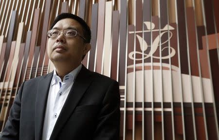 Pro-democracy lawmaker James To poses in front of the Legislative Council logo inside the council building in Hong Kong December 4, 2014. Picture taken December 4. REUTERS/Bobby Yip