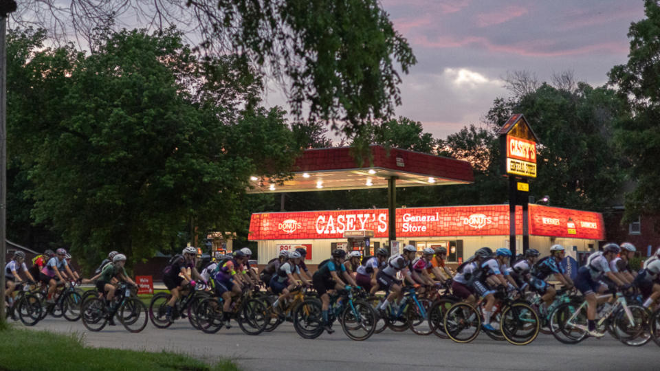 Unbound Gravel 2023 women's elite race rolling past a store