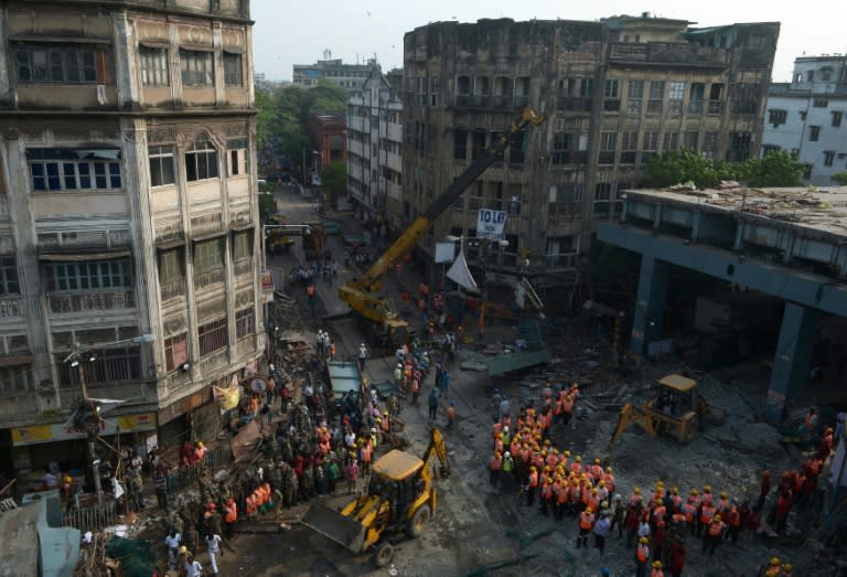 Rescue workers clear away debris amid efforts to free people trapped under the wreckage of a collapsed flyover bridge in Kolkata, eastern India on April 1, 2016