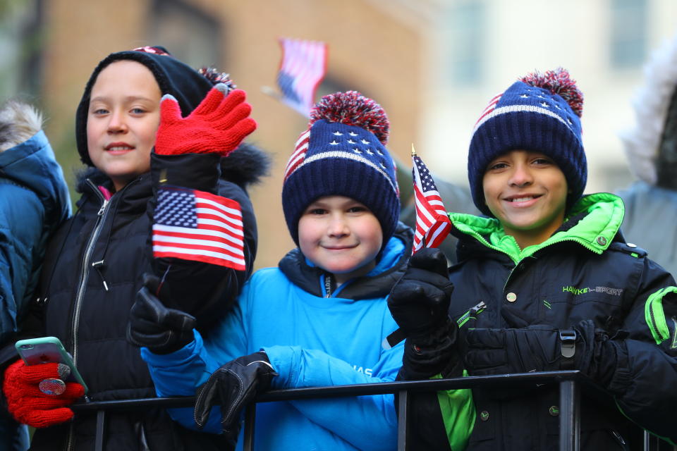 <p>Children wave flags while riding a float during the Veterans Day parade in New York City on Nov. 11, 2017. (Photo: Gordon Donovan/Yahoo News) </p>