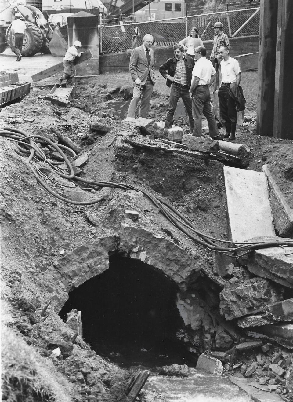 Surveying the damage June 25, 1977, near Glendale Cemetery are U.S. Rep. John Seiberling, Akron City Council Water and Service Committee Chairman Tim Davis, Service Director David Zimmer and Acting City Engineer Bill Wilkerson.