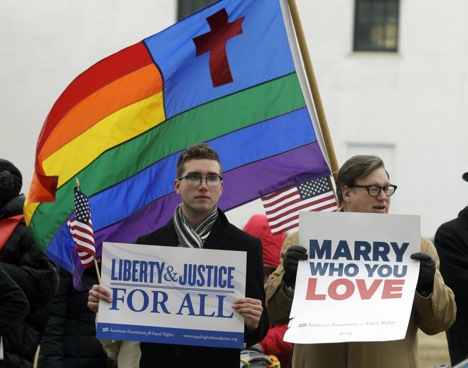 FILE - In this Feb. 4, 2014 file photo, Spencer Geiger, left, of Virginia Beach, and Carl Johanson, of Norfolk, hold signs as they demonstrate outside Federal Court in Norfolk, Va. Less than two weeks after a federal judge declared Virginia’s ban on same-sex marriage unconstitutional, a new effort has been launched in the South seeking to build wider acceptance of gay and lesbian couples in the hope of overturning similar bans across the region. (AP Photo/Steve Helber, File)