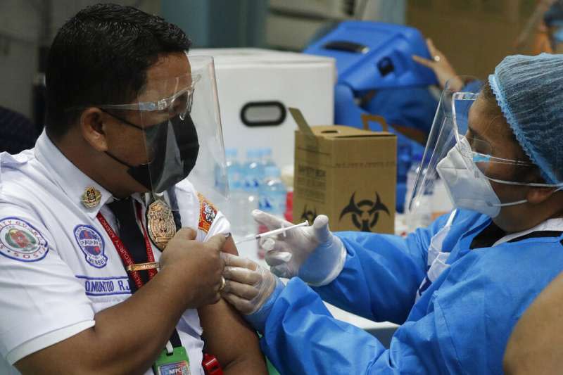 <cite>菲律賓的醫護人員正在為警衛人員施打中國的科興疫苗。（美聯社）</cite>