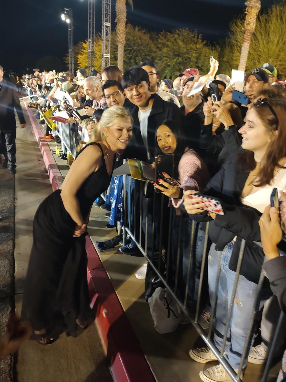 Kirsten Dunst, who accompanied her husband, "Killers of the Flower Moon" star Jesse Plemons, on the red carpet, takes photos with fans at the Palm Springs International Film Awards in Palm Springs, Calif. on Thursday, Jan. 4, 2024.