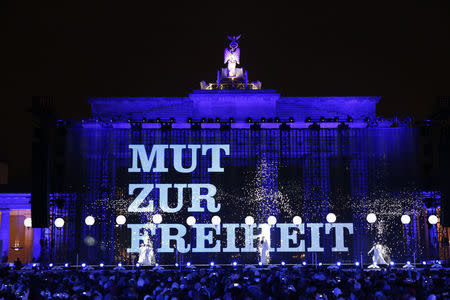 The text reading 'Courage For Freedom' is displayed on a video screen in front of the Brandenburg Gate next to part of the installation 'Lichtgrenze' (Border of Light) in Berlin, November 9, 2014. REUTERS/Fabrizio Bensch