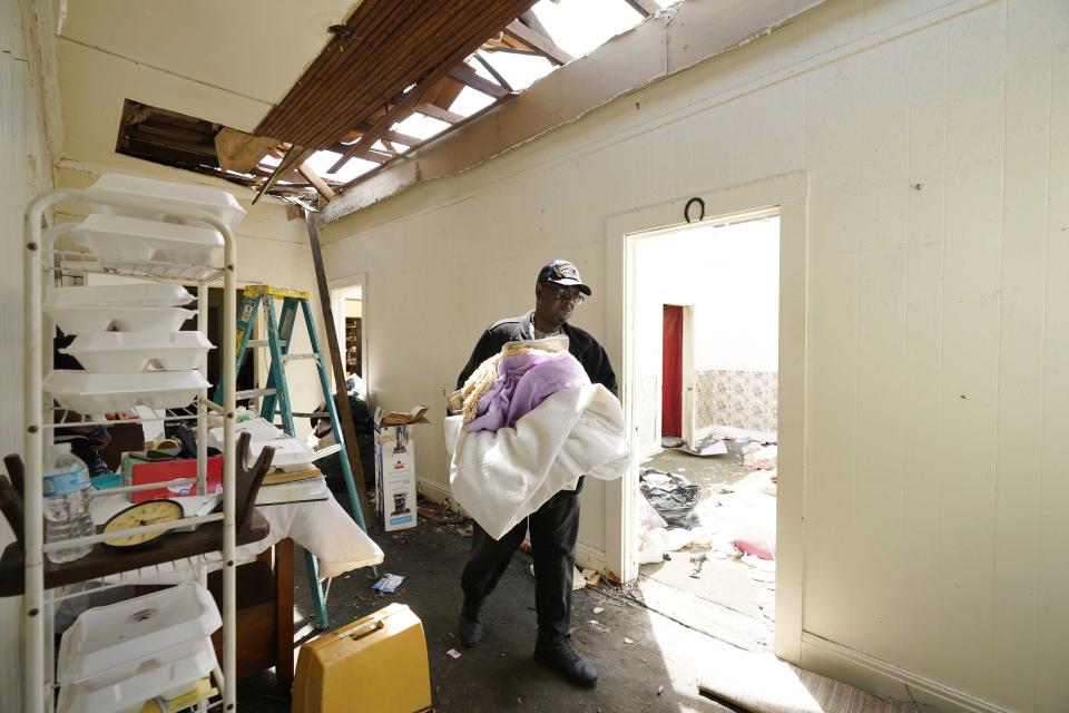 Walker Watkins, a relative of longtime Silver City, Miss., resident Mary Kitchen, walks through the hallway of her destroyed home, carrying out salvageable items, Tuesday, March 28, 2023. The home, like many hit by Friday's tornado in the Mississippi Delta, sustained severe damage. (AP Photo/Rogelio V. Solis)