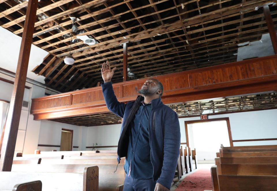 Pastor Gerard Duncan, of Prayers By Faith Ministries, points out the damage and repairs being made to the ceiling and roof in the sanctuary of the Old Mount Carmel Baptist Church building in February 2022.