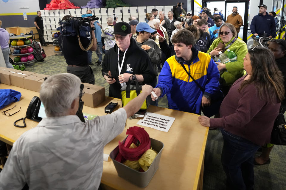 A crowd of bowlers sign up for a lane during the reopening of Just In Time Recreation, six months after a deadly mass shooting, Friday, May 3, 2024, in Lewiston, Maine. (AP Photo/Robert F. Bukaty)