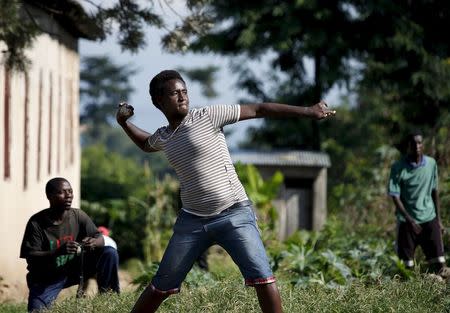 A protester throws stones at police during a protest against president Pierre Nkurunziza in Bujumbura, Burundi, May 10. 2015. REUTERS/Goran Tomasevic