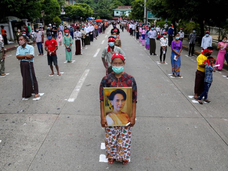 People wear face masks and observe social distancing, as preventive measures against the spread of the COVID-19 novel coronavirus, as they wait to enter the Martyrs' Mausoleum during a ceremony for Martyrs' Day in Yangon on July 19, 2020. - Myanmar observed the 73rd anniversary of Martyrs' Day on July 19, marking the assassination of independence heroes including Aung San Suu Kyi's father, who helped end British colonial rule. (Photo by Sai Aung Main / AFP) (Photo by SAI AUNG MAIN/AFP via Getty Images)