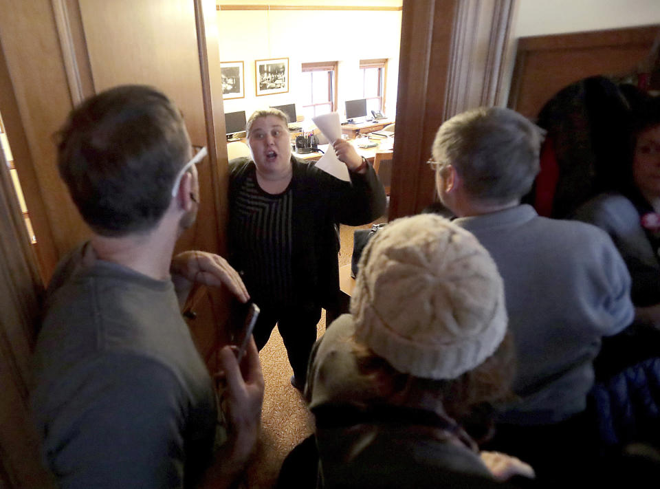 Opponents of an extraordinary session bill submitted by the state's Republicans are told to quiet down by Sergeant of Arms staffer Jeanine Schneider outside a public hearing regarding the bill at the Wisconsin State Capitol in Madison, Wis., Monday, Dec. 3, 2018. (John Hart/Wisconsin State Journal via AP)