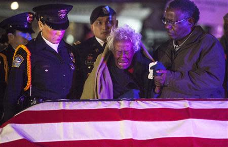 Clara Gantt, the 94-year-old widow of U.S. Army Sgt. Joseph Gantt, weeps in front of her her husband's casket after it was lowered from the plane before dawn on the tarmac at Los Angeles International Airport in Los Angeles, California December 20, 2013. REUTERS/Andrew Renneisen/Los Angeles Times/Pool