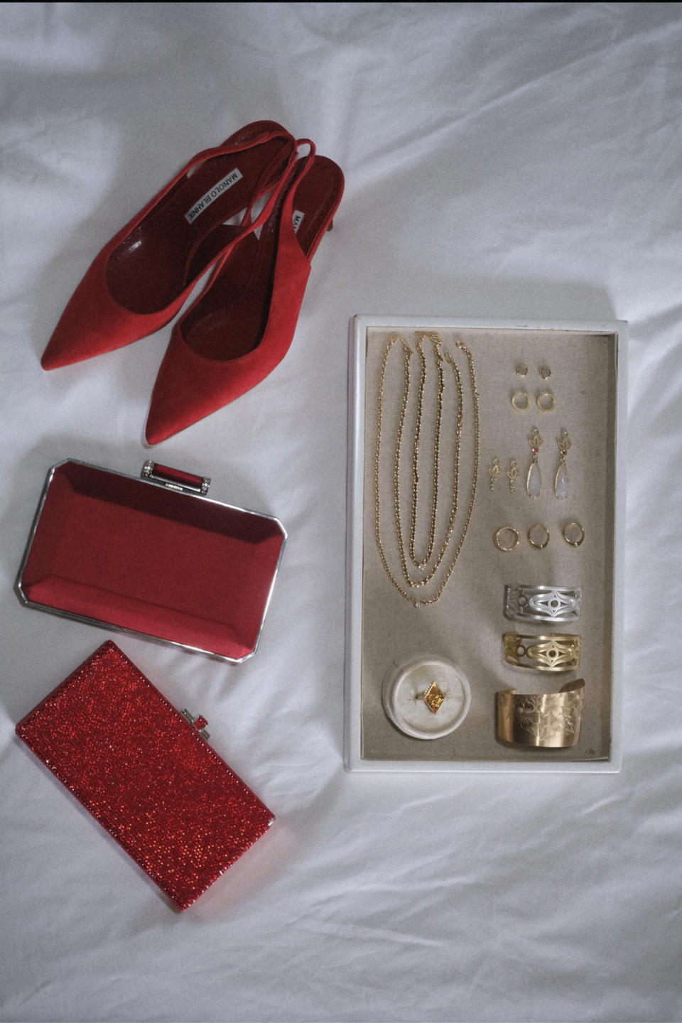 Shoes by Manolo Blahnik, Judith Leiber clutches, Robin Waynee earrings, and additional jewelry by Lizzie Mandler, and Jennifer Younger Designs.