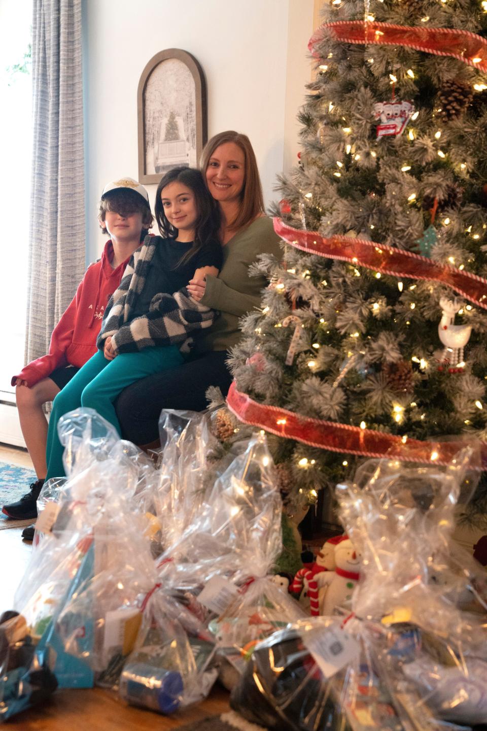 Dec 2, 2023; Rockaway, NJ, United States; Three years ago, Rockaway’s Cathy Vonk passed a giving tree in Denville and decided to help. Supported by friends and family, she raised $2,300 and bought gifts for 58 children. She has helped hundreds since. Cathy Vonk with her children Grace, 8, and Vince, 11, at their home near a pile of gifts that will be donated.