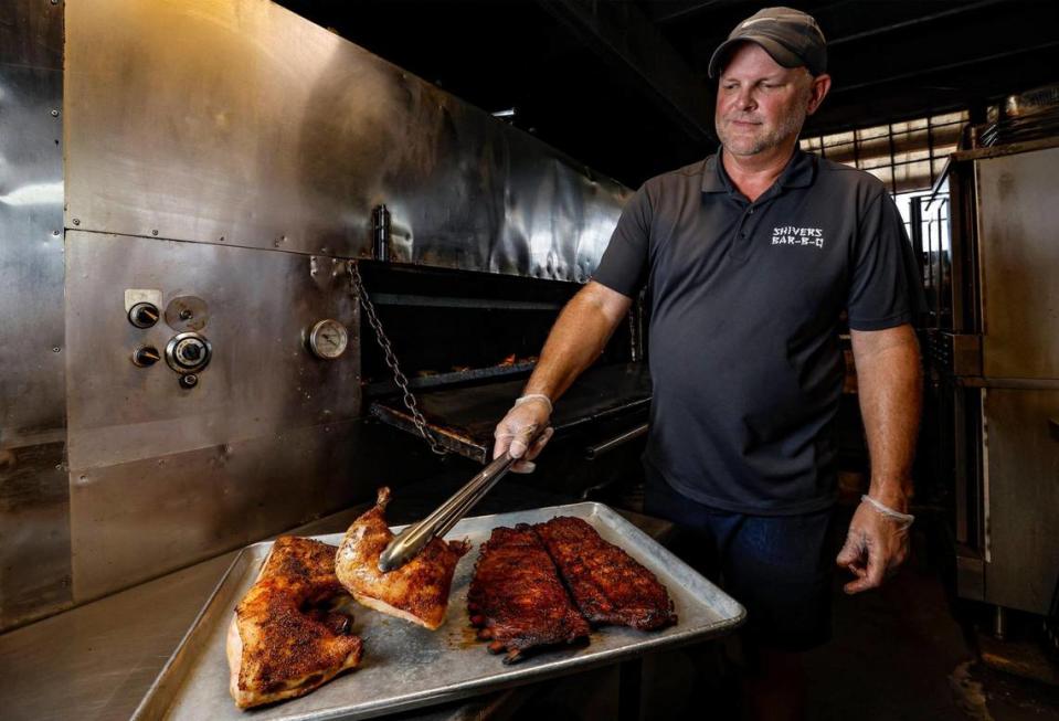 El propietario Michael Campbell recoge pollo y costillas del ahumador en Shiver's Bar-B-Q en Homestead, Florida, el viernes 7 de julio de 2023.