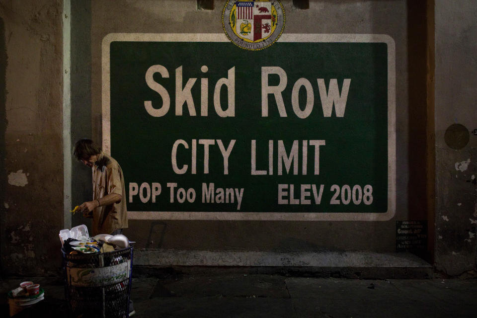 FILE - In this Oct. 28, 2017, file photo, a homeless man takes food from a trash can in Los Angeles' Skid Row area, home to the nation's largest concentration of homeless people in Los Angeles. California has spent $13 billion in the last three years to tackle a massive homelessness problem likely to worsen with the pandemic, yet its approach is so disjointed and incomplete as to hinder efforts at getting people into stable housing, the state auditor said in a report released Thursday, Feb. 11, 2021. (AP Photo/Jae C. Hong, File)