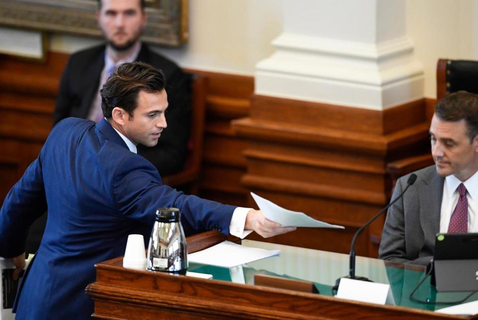 Attorney Anthony Osso hands evidence to Ryan Bangert, former first deputy assistant of suspended Attorney General Ken Paxton, on day three of suspended Attorney General Ken Paxton's impeachment trial in the Texas Senate on September 7, 2023.
