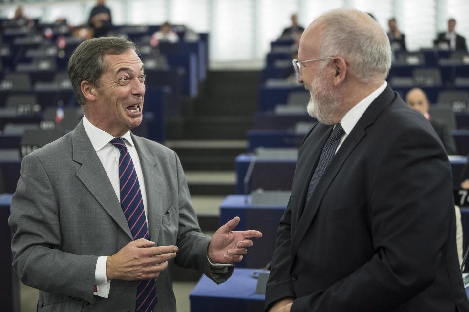 Nigel Farage, left, former leader of the British UKIP party and member of the European Parliament, discusses with Frans Timmermans, first vice president of the European Commission at the European Parliament in Strasbourg, eastern France, Tuesday Sept.11, 2018. The European Parliament debates whether Hungary should face political sanctions for policies that opponents say are against the EU's democratic values and the rule of law. (AP Photo/Jean-Francois Badias)