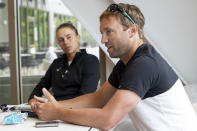 Coach Mark Gellard talks about coaching in the WTA as player Magda Linette listens at the Charleston Open tennis tournament in Charleston, S.C., Monday, April 3, 2023. Gellard is helping new coaches in the WTA's new program to develop female coaches. (AP Photo/Mic Smith)