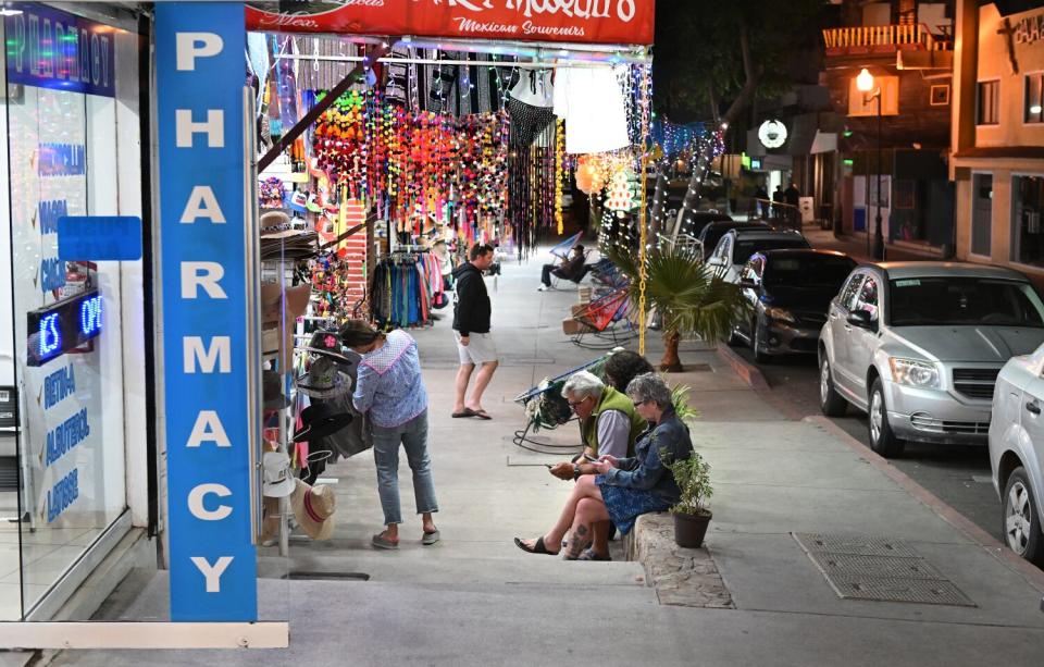 A street with shops. One has a vertical sign that says 