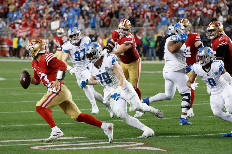 49ers quarterback Brock Purdy looks to run the ball around Lions defensive end John Cominsky in the third quarter of the Lions' 34-31 loss in the NFC championship game in Santa Clara, California, on Sunday, Jan. 28, 2024.