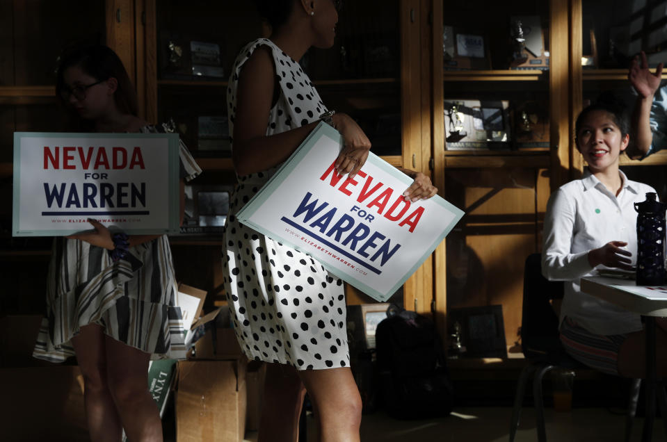 FILE - In this Aug. 2, 2019 file photo, people hand out signs before a rally with Democratic presidential candidate Sen. Elizabeth Warren, D-Mass., in Henderson, Nev. (AP Photo/John Locher)