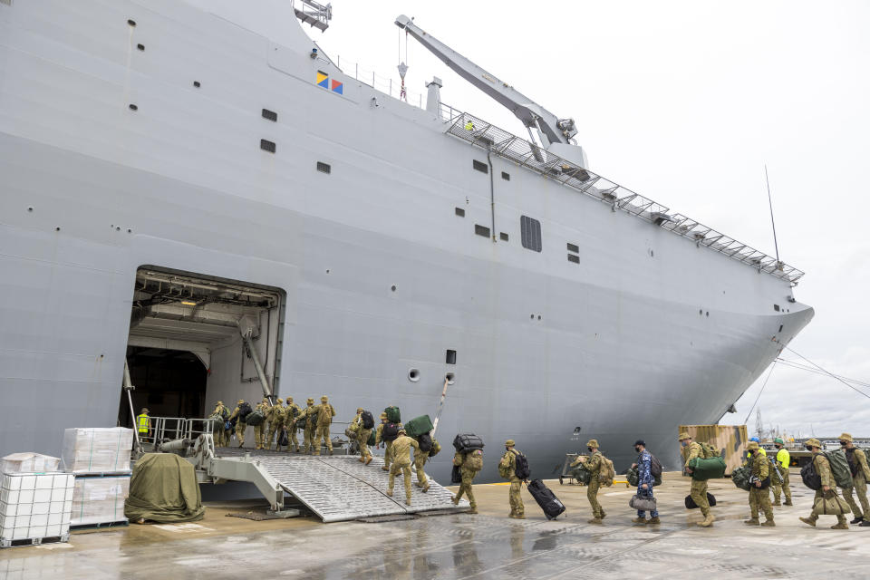 In this photo provided by the Australian Defence Force, soldiers load onto HMAS Adelaide at the Port of Brisbane before departing for Tonga Thursday, Jan. 20, 2022, after a volcano eruption. U.N. humanitarian officials report that about 84,000 people — more than 80% of Tonga's population — have been impacted by the volcano's eruption. (Cpl. Robert Whitmore/Australia Defence Force via AP)