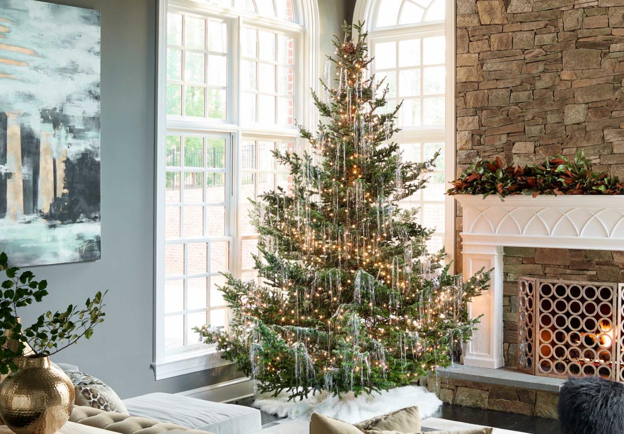  A living room with a christmas tree covered in tinsel. 