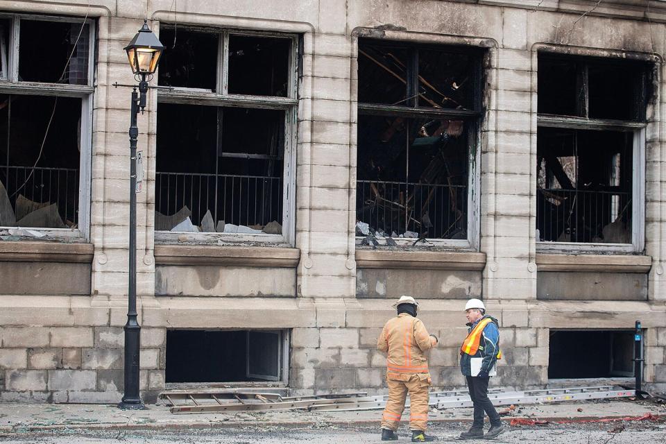 Investigators and firefighters are shown at the scene following a fire in Old Montreal, Saturday, March 18, 2023, that gutted the heritage building