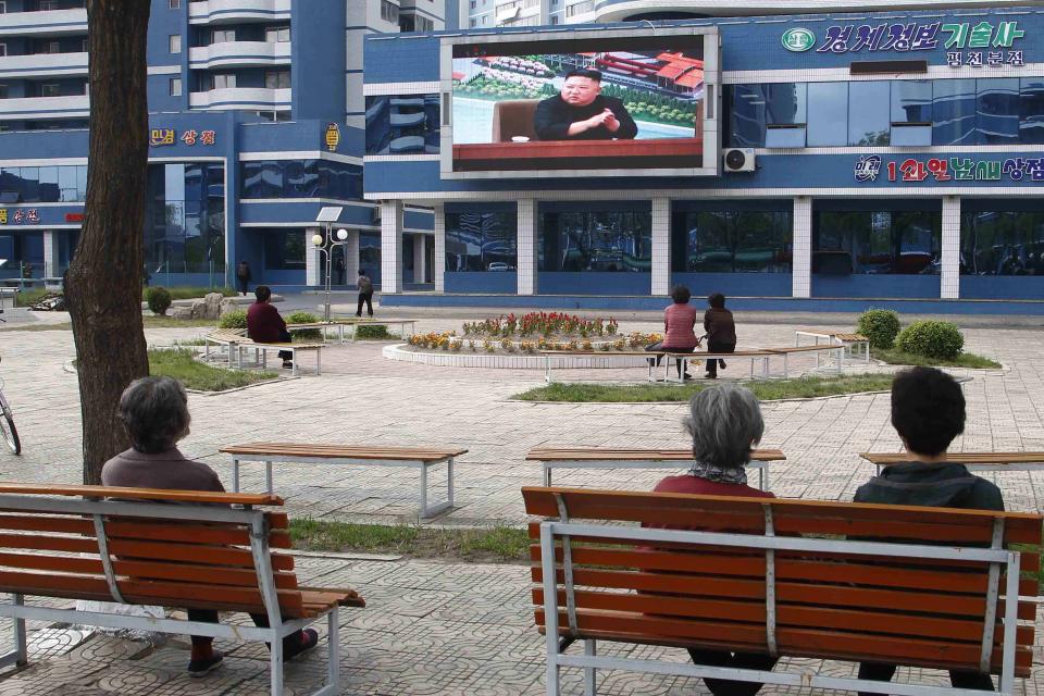 People in a park watch news broadcasted on a giant screen showing leader Kim Jong Un attending the opening ceremony of the Sunchon Phosphatic Fertilizer Factory Saturday, May, 2nd. 2020, in Pyongyang, North Korea. Un made his first public appearance in 20 days as he celebrated the completion of a fertilizer factory near Pyongyang, state media said Saturday, ending an absence that had triggered global rumors that he may be seriously ill. (AP Photo/Cha Song Ho)