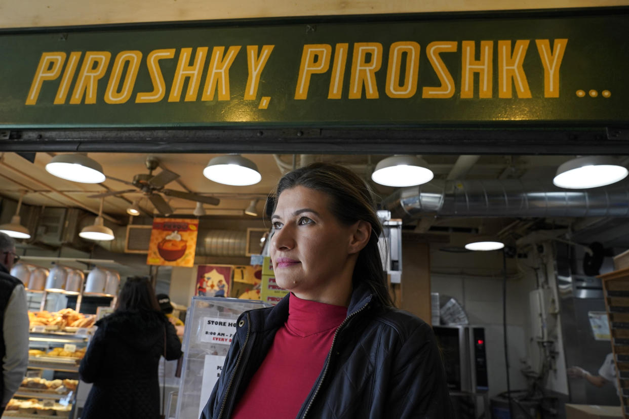 Olga Sagan, the owner of Russian bakery Piroshky Piroshky, poses for a photo in front of her business Wednesday, March 16, 2022, at Pike Place Market in Seattle, where a recent caller threatened to stage a terrorist attack on the store. (AP Photo/Ted S. Warren)