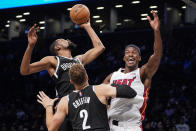 Brooklyn Nets forward Kevin Durant, left, rebounds against Miami Heat forward Jimmy Butler, right, during the first half of an NBA basketball game, Wednesday, Oct. 27, 2021, in New York. (AP Photo/John Minchillo)