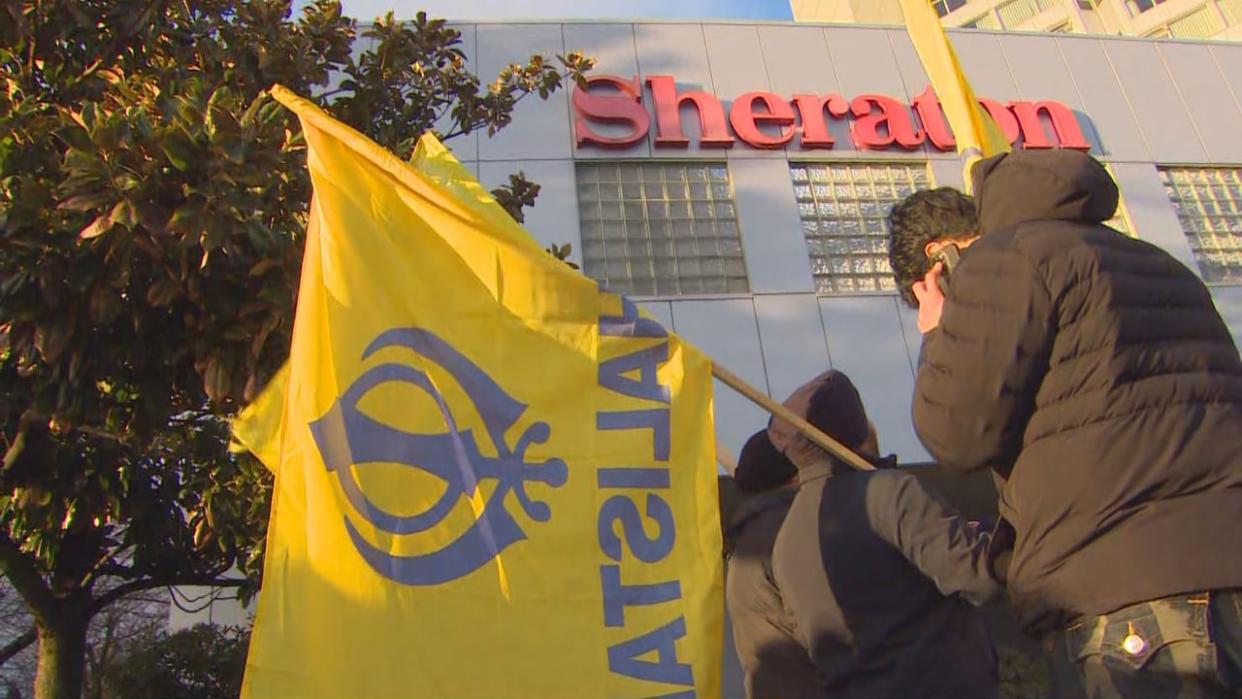 Demonstrators wave the Khalistan flag outside Sheraton Guildford Hotel in Surrey on Friday, March 1, 2024. (CBC News - image credit)