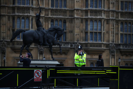 A police officer stands at the vehicle barrier to the Houses of Parliament where a car crashed after knocking down cyclists and pedestrians yesterday in Westminster, London, Britain, August 15, 2018. REUTERS/Hannah McKay