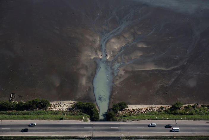 <p>In this July 5, 2016 photo, cars drive above sewage flowing from the suburb of Sao Goncalo into Guanabara Bay, across the bay from Rio de Janeiro, Brazil. Throughout Brazil, sewage treatment has lagged dramatically, meaning that so-called ‘black tongues’ of fetid, sewage-filled water are common on beaches across the country. (AP Photo/Felipe Dana)