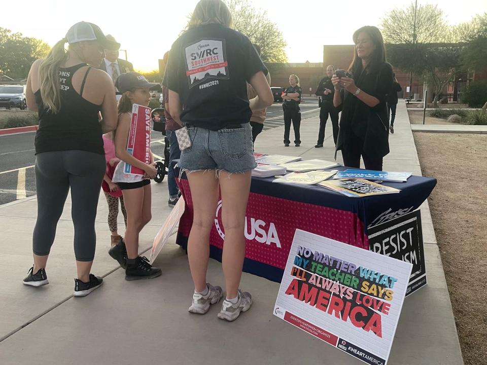 Parents pick up brochures from Turning Point USA, a conservative political group based in Phoenix, ahead of the Scottsdale school board meeting on Nov. 15, 2021.