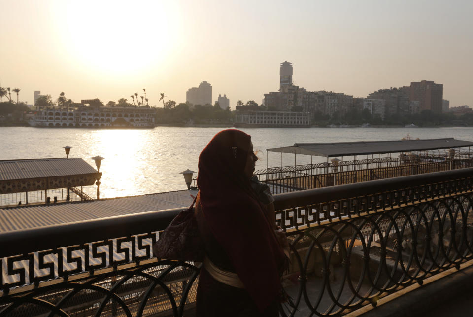 In this Sunday, Sept. 8, 2013 photo a woman enjoys the view by the Nile river in Cairo, Egypt. Before the 2011 revolution that started Egypt's political roller coaster, sites like the pyramids were often overcrowded with visitors and vendors, but after a summer of coup, protests and massacres, most tourist attractions are virtually deserted to the point of being serene. (AP Photo/Lefteris Pitarakis)