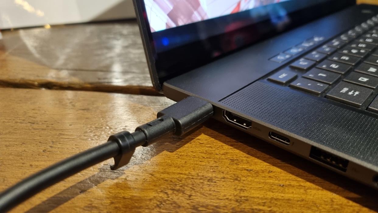  A charging cable plugged into an Asus Zephyrus G16 gaming laptop. 